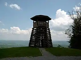 A wooden observation tower overlooking a forested valley.