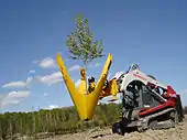 A tree spade on an older model Takeuchi track loader.