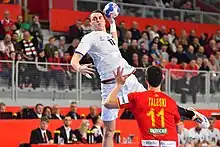 Stanislav Kašpárek jumping into the air with a handball in his hand about to shoot on goal infront of a crowded statium