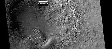 Layered structure in crater that is probably what is left of a layered unit that once covered a much larger area.  Material for this unit fell from the sky as ice-coated dust.  The picture was taken by HiRISE, under the HiWish program.   Picture is from Hellas quadrangle.