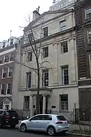  A light tan stone townhouse with an entrance portico