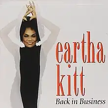 A photograph of Eartha Kitt standing behind a sheer drapery.