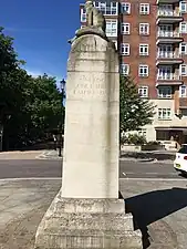 East face of memorial. Inscription reads "One King, One Empire,Empire Day". Trees of Kensington Gardens visible on the left