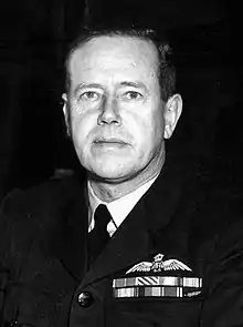 Head-and-shoulders portrait of man in dark military uniform with ribbons and pilot's wings on chest