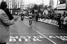 A cyclist holding his hands aloft.