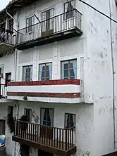 An image of a rugged building with printed pictures of windows as opposed to real glass with curtains and framing.