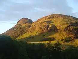 An irregular grass-covered mountain near sunset.