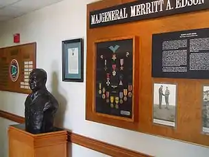 A bust of Edson next to a display of his medals and photographs