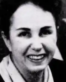 A smiling middle-aged white woman with dark hair