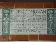 A tablet formed of six standard sized tiles, bordered by green flowers in the style of the Arts and Crafts movement