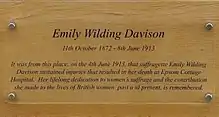 Plaque dedicated to Davison. In addition to her name and dates, the text reads "It was from this place, on the 4th June 1913, that suffragette Emily Wilding Davison sustained injuries that resulted in her death at Epsom Cottage Hospital. Her lifelong dedication to women's suffrage and the contribution she made to the lives of British women past and present, is remembered.