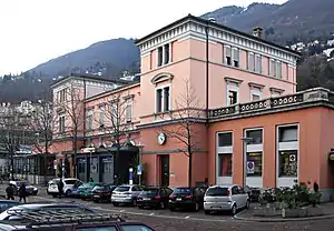 Stone building with two three-story towers with hipped roofs and single story wings