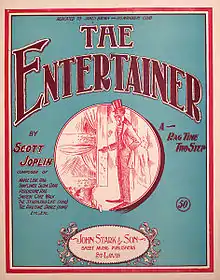 The front cover of "The Entertainer"'s sheet music. It has a green background and in the center is a red ink drawing of a caricatured African-American performer on stage in top hat and tails