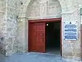 The stone plaque at the entrance to the church gives information in four languages