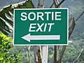 An exit sign in Mauritius in French (roman) and English (italics)