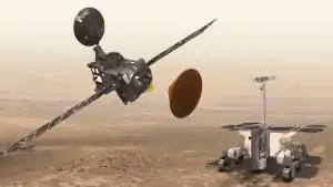 Image depicting the three spacecraft of the mission, an orbiter at left, lander at center, and rover at right, against a Martian landscape and sky.