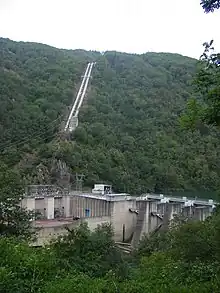 Power station next to a river dam, with two steel tubes bringing water from an unseen lake 500 m above