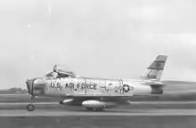 A jet is seen perpendicular to the camera while parked on the ground