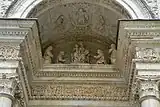 Relief under the portal arch portraying two couples of Carthusians paying homage to the Virgin and Child.