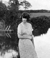 young white woman in open air setting; she has medium-length dark hair