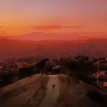 Finneas runs away from a city, the background shows the sun setting.