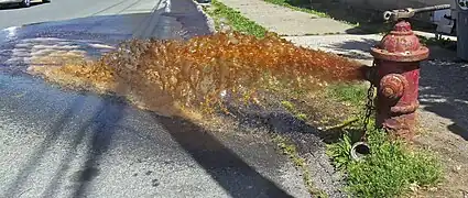 A fire hydrant without a diffuser, flushing discolored water