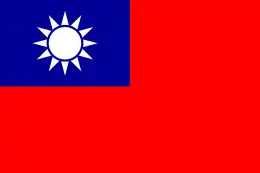 A red flag, with a small blue rectangle in the top left hand corner on which sits a white sun composed of a circle surrounded by 12 rays.