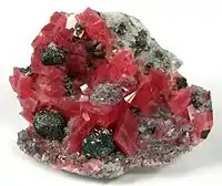 Rhodochrosite with fluorite, tetrahedrite and quartz; the tetrahedrite occurs as sharp, metallic crystals