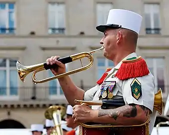 A Caporal-chef, with 3 chevrons of seniority, bugling during the Bastille Day Military Parade.