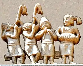 Detail of the foreigners, in Greek dress and playing carnyxes and aolus flute. Northern Gateway of Stupa I (detail).