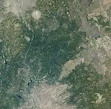 A satellite image from 2001 shows a distinct brown fire scar surrounded by green