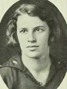 A young white woman with bobbed hair, wearing a dark dress or top with an open collar