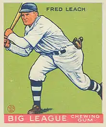 A baseball card image of a man in a white baseball uniform and blue baseball cap swinging a baseball bat