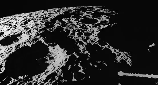 View of the west rim of the basin while at the sunset terminator during the Apollo 16 mission. Spencer Jones is in the lower left, and the spacecraft's gamma-ray spectrometer is in lower right.