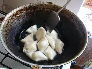 Kyrgyz boorsoq being fried in a stove-top kazan.