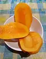 Fully ripe Chok Anan mango cut into three pieces.