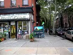 A reopened subway station entrance on South Portland Avenue, at the "G" train's Fulton Street station. This entrance consists of a staircase that descends underground; it is surrounded by a forest-green banister.