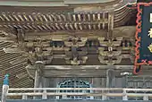 Brackets (tokyō, futatesaki in this case) under the eaves of a sanmon's roof.