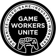 A black and white logo in concentric circles. On the inside: "Game Workers Unite", with a fist clutching a game controller. On the outside: "Organize video game industry workers."