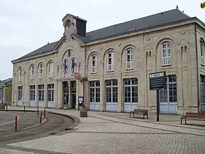 Wide two-story stone building with hipped roof