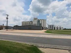 Silos can be seen on Texas 71 across from the school.