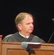 Justice James sitting at a dais