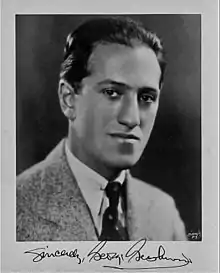 Head and shoulders picture of a young man with slicked back dark hair and a signature on the bottom