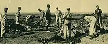 A party of German prisoners works the ground with picks under the supervision of a French guards