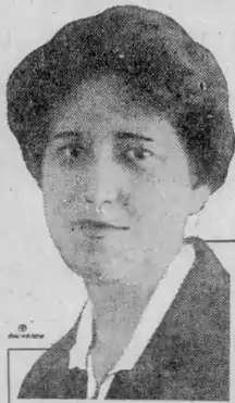 White woman wearing a collared shirt and jacket.