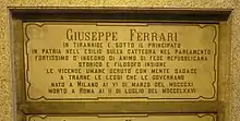 A marble gravestone on the wall of a crypt