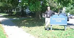 Errin Gnadinger, grandnephew of Frank and Norb Gnadinger, and grandson of Carl Gnadinger next to the Gnadinger Park sign at the intersection of Reutlinger and Ellison Avenues in Louisville, Kentucky.