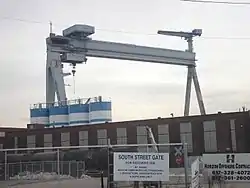 A large crane sits over an empty shipyard