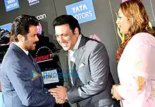 Govinda and Anil Kapoor shake hands, as Govinda's wife looks on