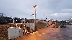 Concrete ramps and steps leading up to side platform